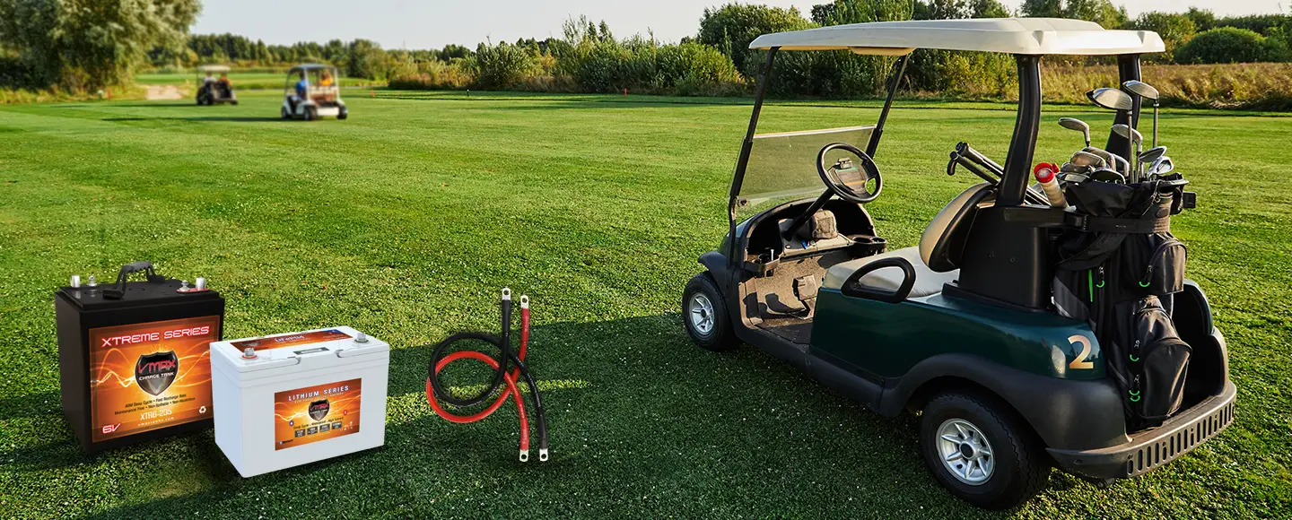 Premium VMAX XTR6-235 6V AGM and LiFePO4 lithium golf cart batteries with heavy-duty cables on a sunny fairway.